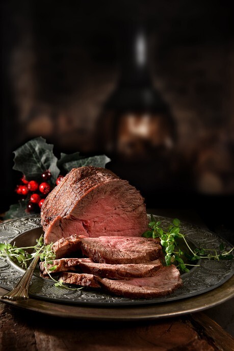 Weihnachtsbraten Rosa gebratener Weihnachtsbraten auf einem großen silbernen Teller